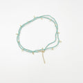 Beads necklace featuring 18 karat gold plated ornaments that can be styled as a bracelet or belt. - ELLY